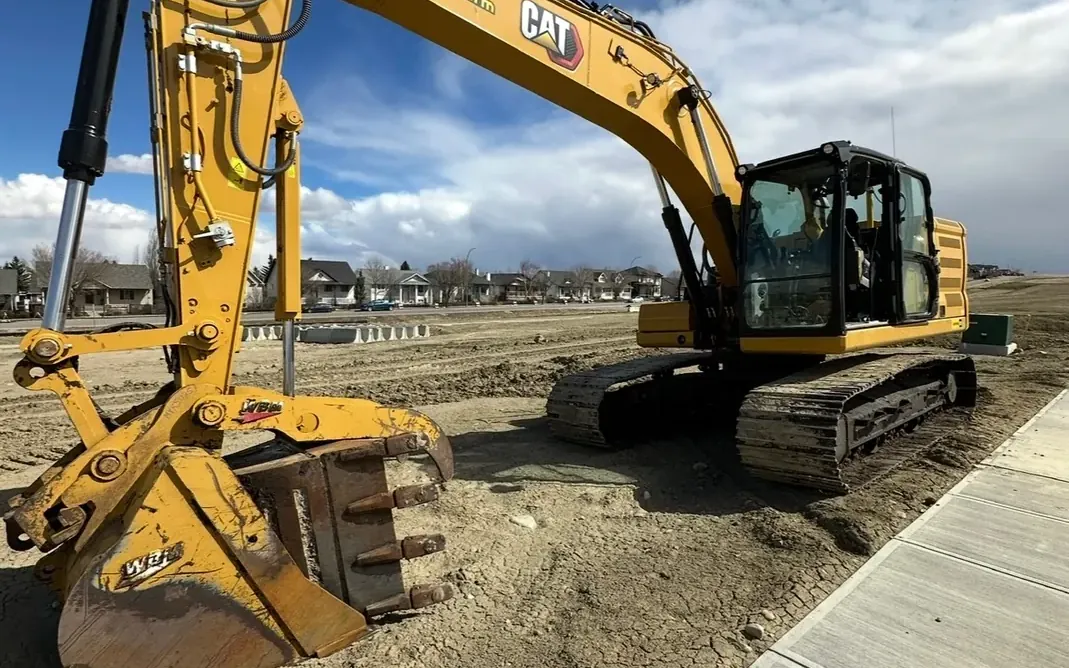 CAT excavator on a Calgary job site after an on-site wash