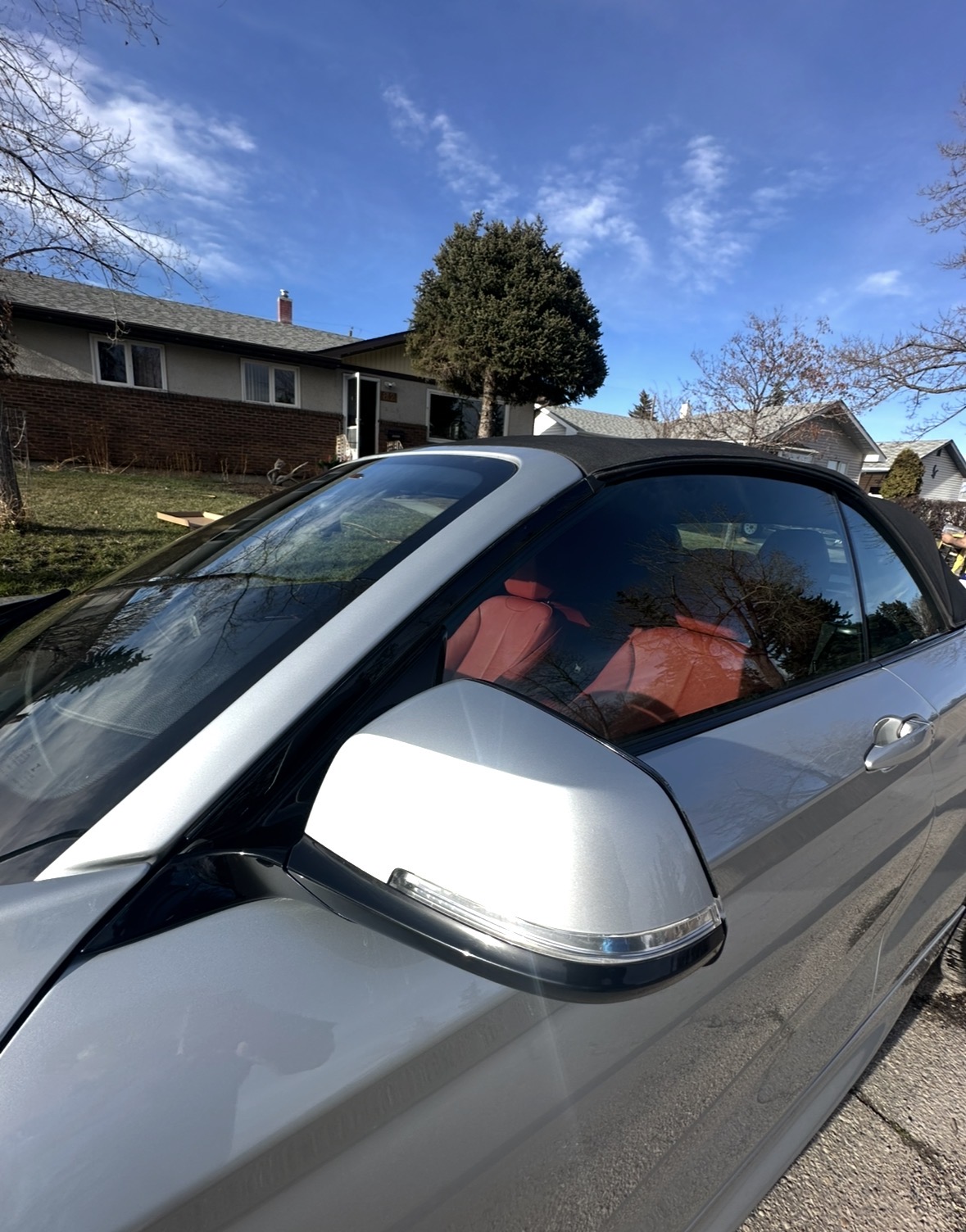BMW convertible side mirror with red leather visible inside